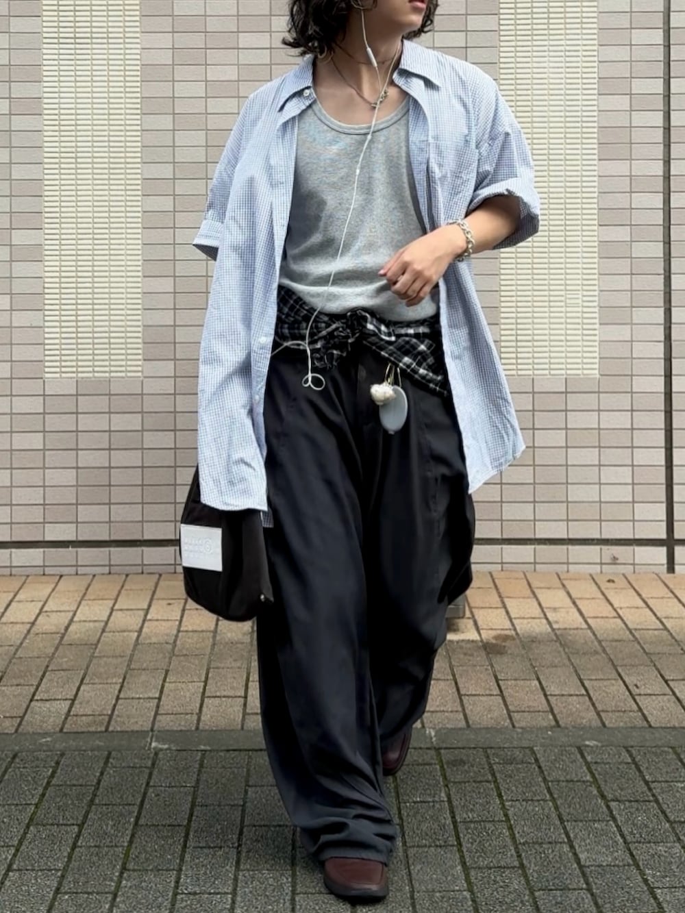グレー系のデニムパンツ、ブルー系のシャツ/ブラウス、ブラック系のハンドバッグを着用したメンズの夏コーディネートの2枚目の写真