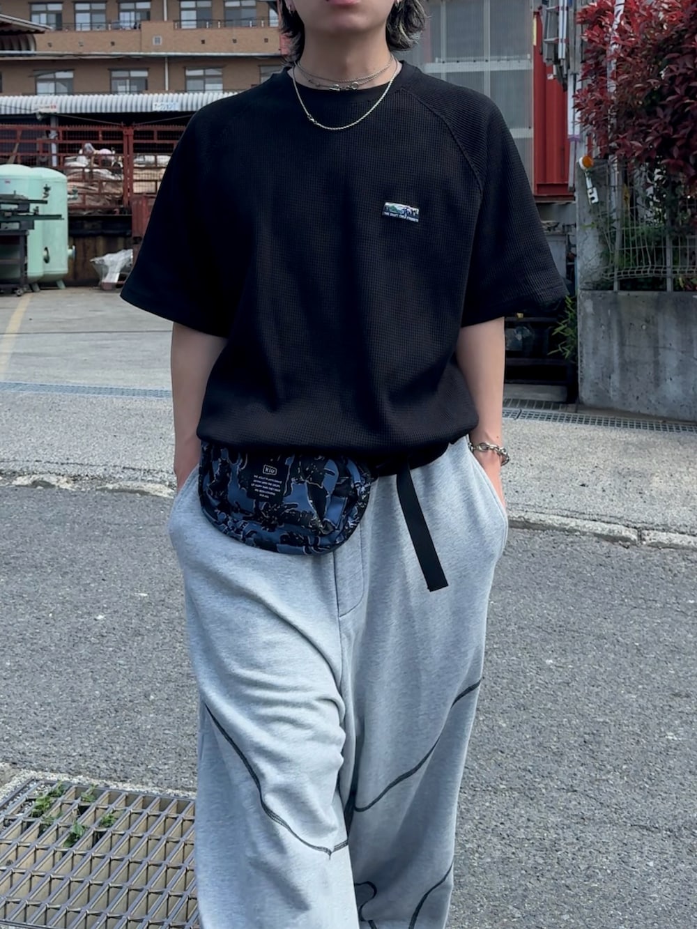 グレー系のスウェットパンツ、その他のボディバッグ/ウエストポーチ、ブラック系のTシャツ/カットソーを着用したメンズの春コーディネートの2枚目の写真
