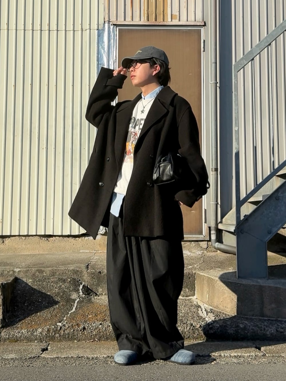 ブルー系のスラックス、レッド系のボストンバッグ、グレー系のスウェットを着用したメンズの冬コーディネートの2枚目の写真