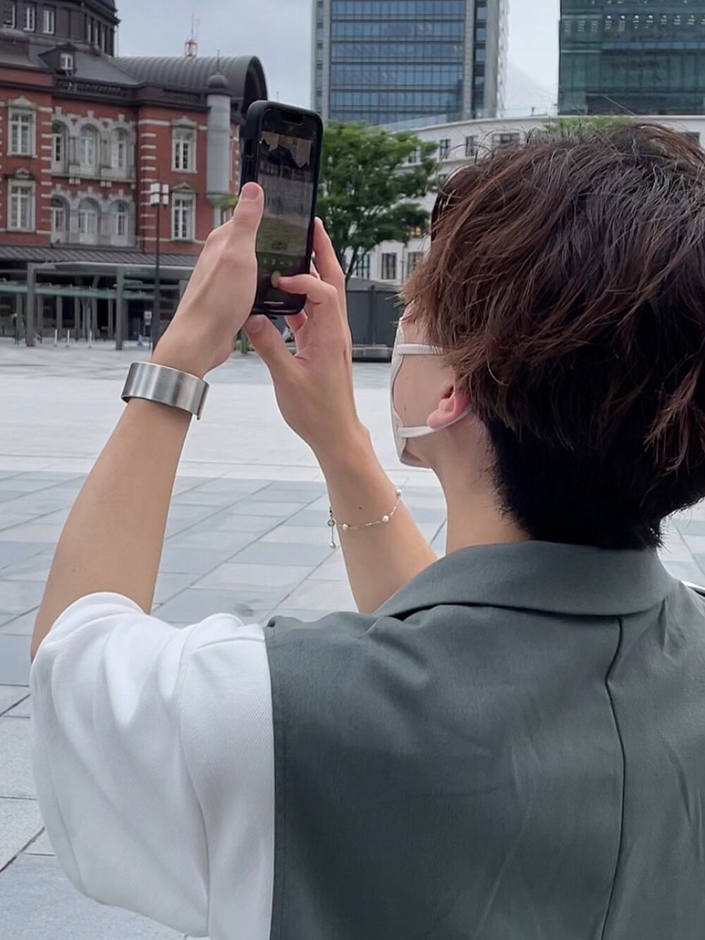 グリーン系のトートバッグ、グリーン系のセットアップ、ホワイト系のポロシャツを着用したメンズの夏コーディネートの3枚目の写真