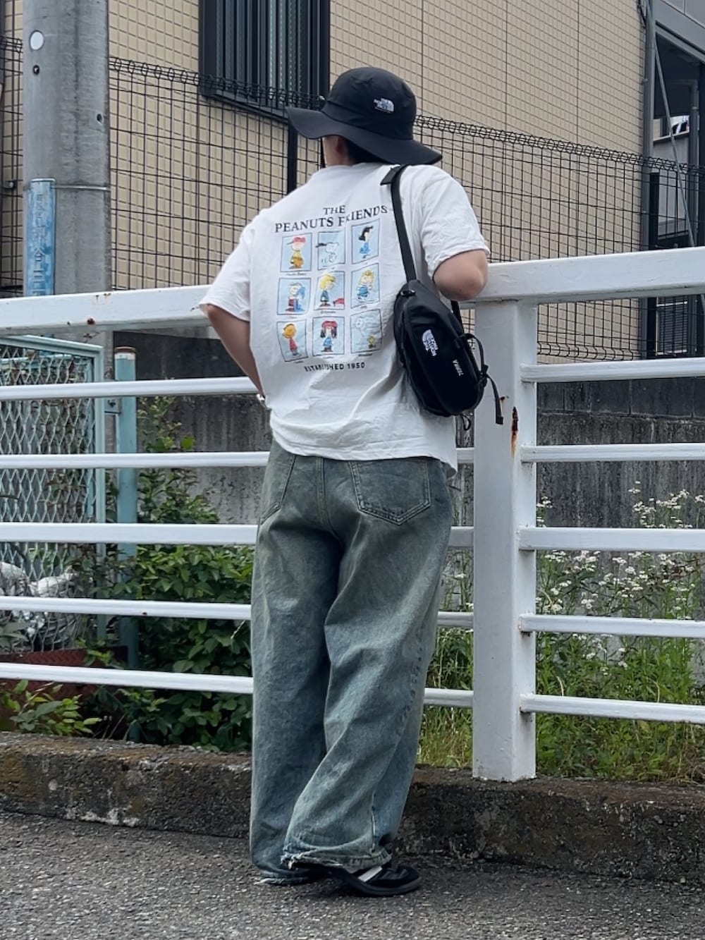 ホワイト系のTシャツ/カットソー、ブラック系のショルダーバッグ、ブルー系のデニムパンツを着用したメンズの夏コーディネートの2枚目の写真