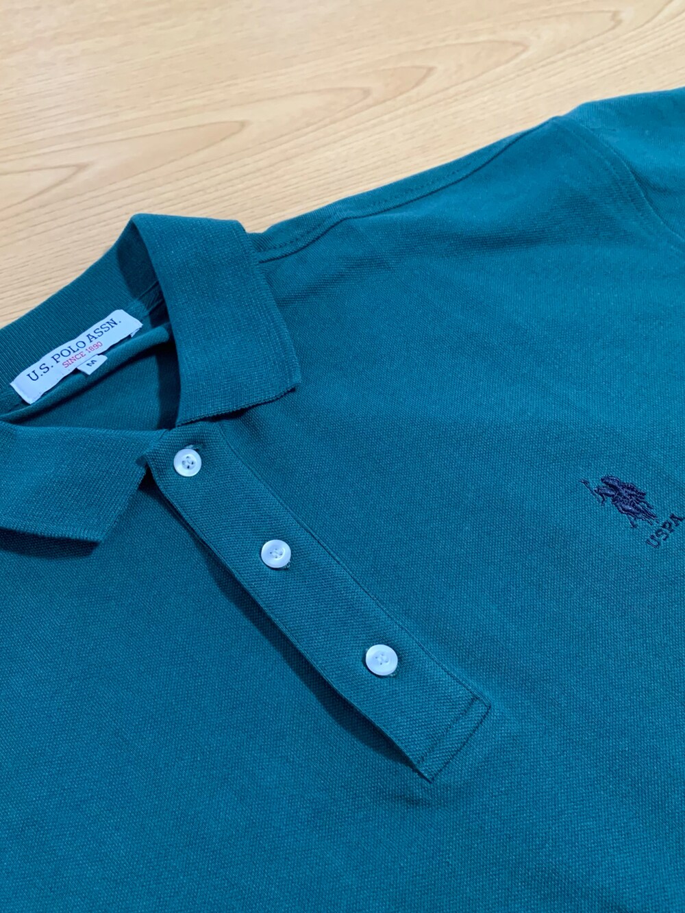 ブルー系のデニムジャケット、グリーン系のポロシャツ、ベージュ系のチノパンツを着用したメンズの春コーディネートの2枚目の写真