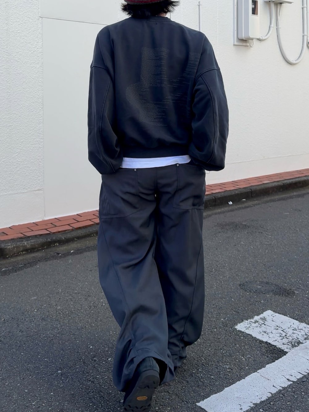 グレー系のデニムパンツ、ブルー系のスウェット、ブラック系のスニーカーを着用したメンズの冬コーディネートの3枚目の写真