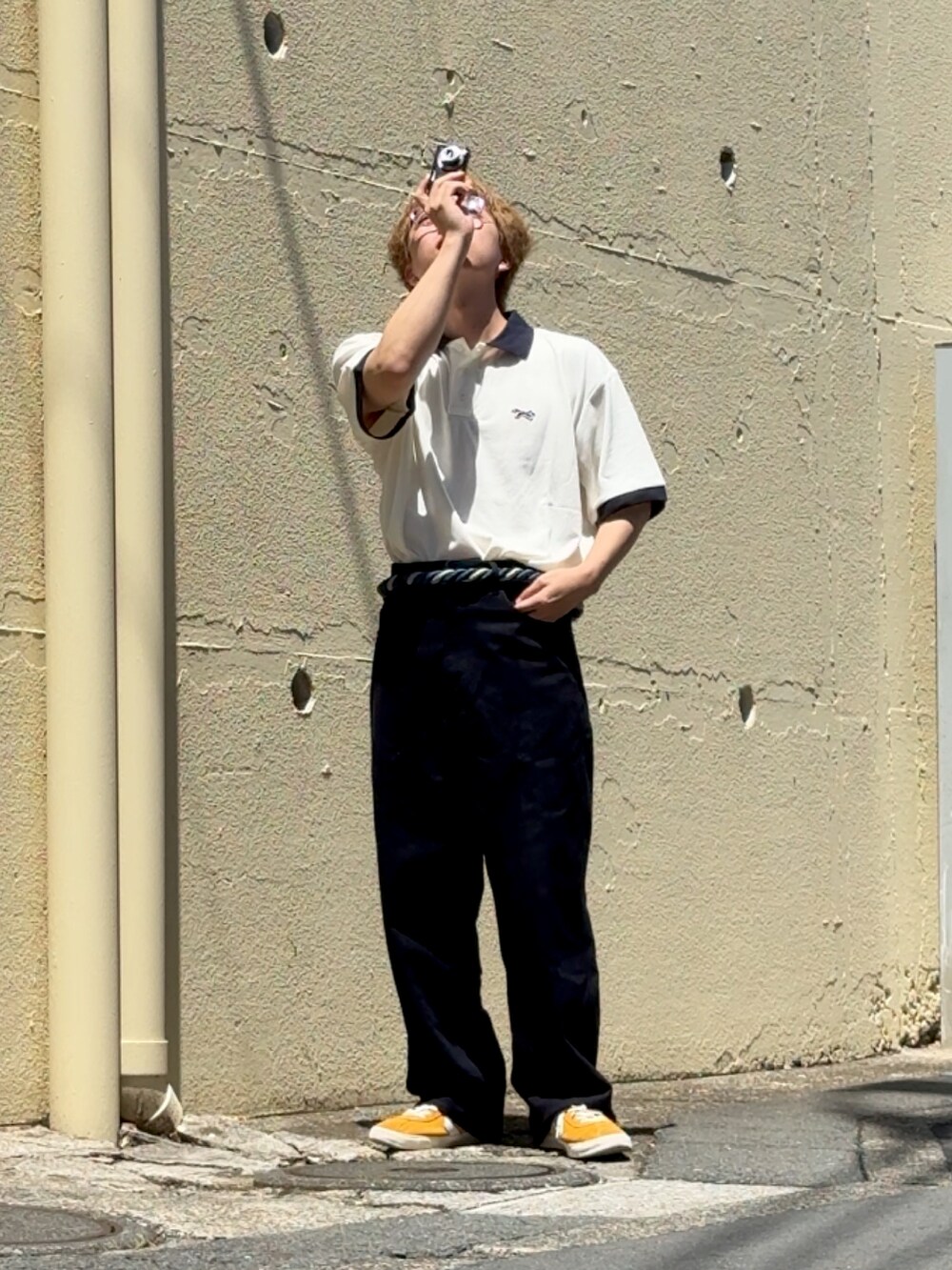 イエロー系のスニーカー、ブルー系のその他パンツ、ホワイト系のポロシャツを着用したメンズの夏コーディネートの2枚目の写真