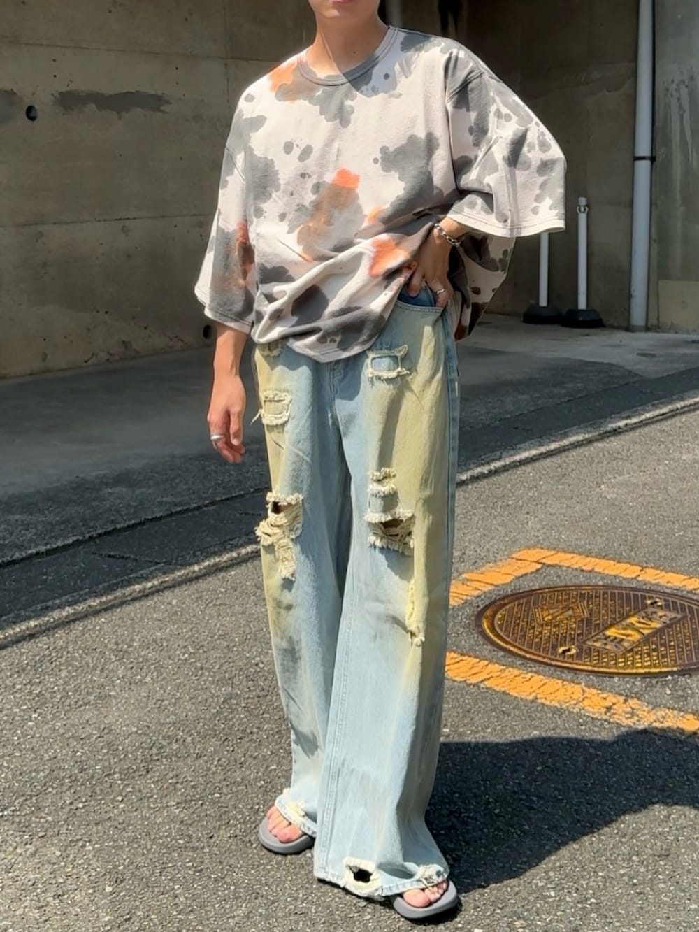 グレー系のサンダル、ブルー系のデニムパンツ、ブラック系のTシャツ/カットソーを着用したメンズの夏コーディネートの3枚目の写真