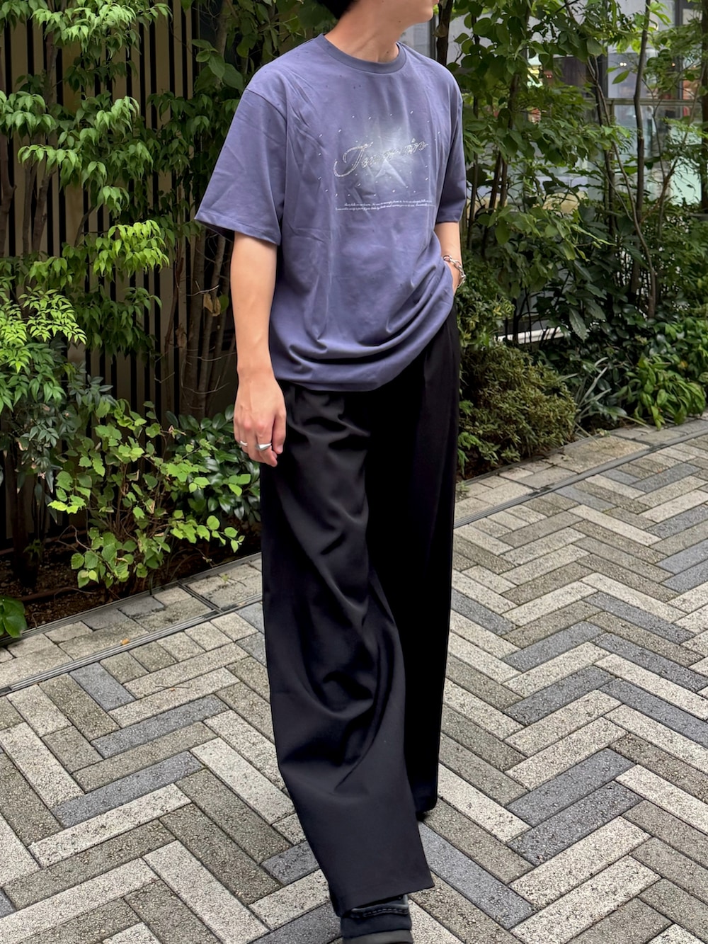 ブラック系のスラックス、ブルー系のTシャツ/カットソー、ブラック系のスニーカーを着用したメンズの夏コーディネートの2枚目の写真