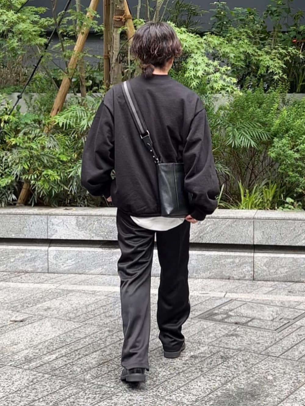 ブラック系のスウェット、ホワイト系のTシャツ/カットソー、ブラック系のドレスシューズを着用したメンズの春コーディネートの3枚目の写真