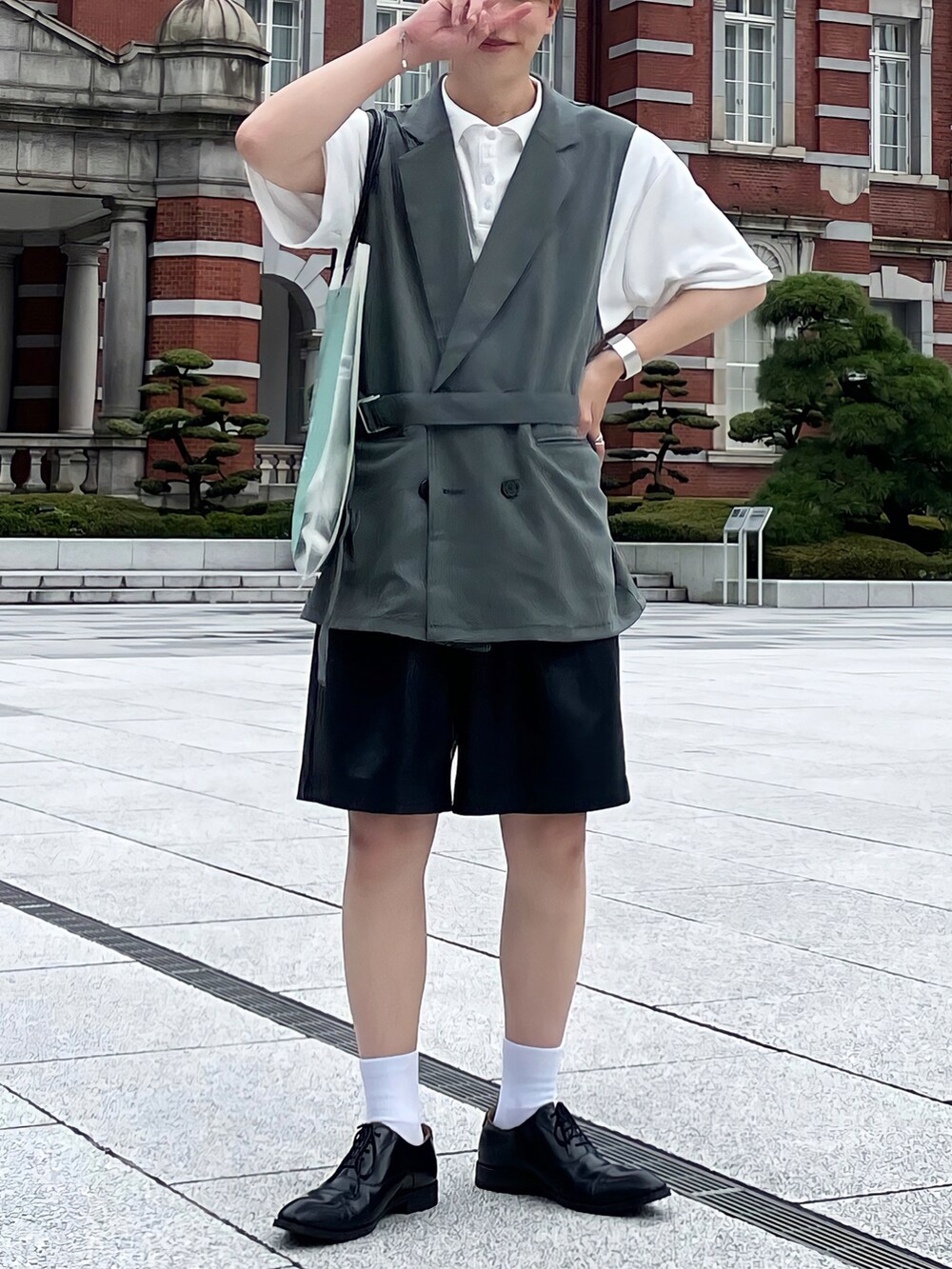 グリーン系のトートバッグ、グリーン系のセットアップ、ホワイト系のポロシャツを着用したメンズの夏コーディネートの2枚目の写真