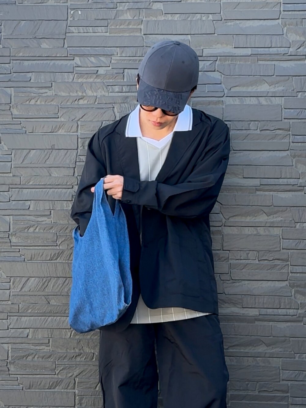 ブラック系のローファー、ブラック系のセットアップ、ブルー系のショルダーバッグを着用したメンズの春コーディネートの2枚目の写真