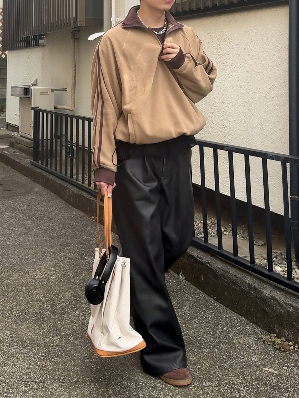 ブラック系のその他パンツ、ベージュ系のボストンバッグ、ブラウン系のスニーカーを着用したメンズの秋コーディネートの3枚目の写真