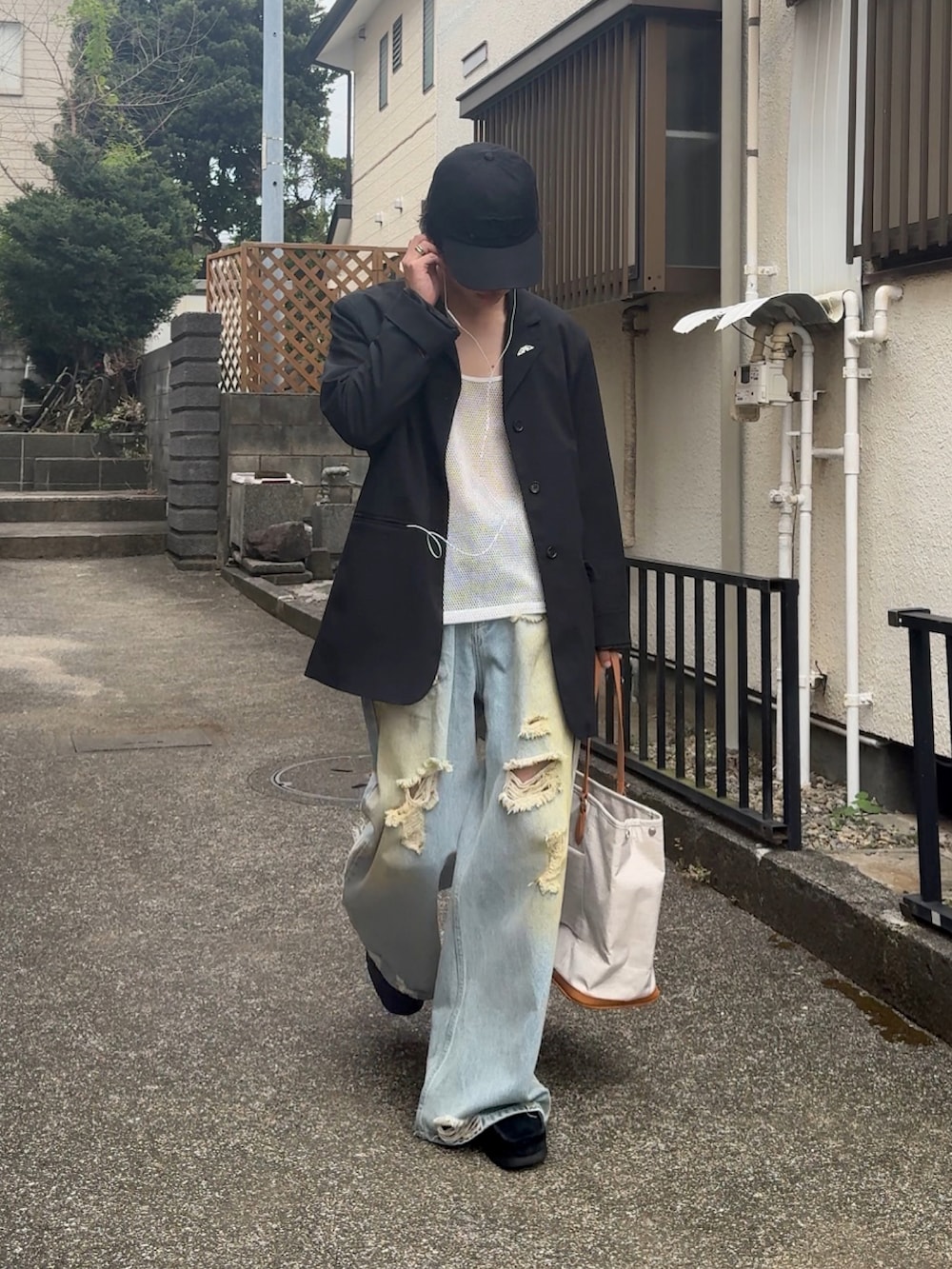 ベージュ系のボストンバッグ、ブラック系のテーラードジャケット、ブルー系のデニムパンツを着用したメンズの秋コーディネートの2枚目の写真