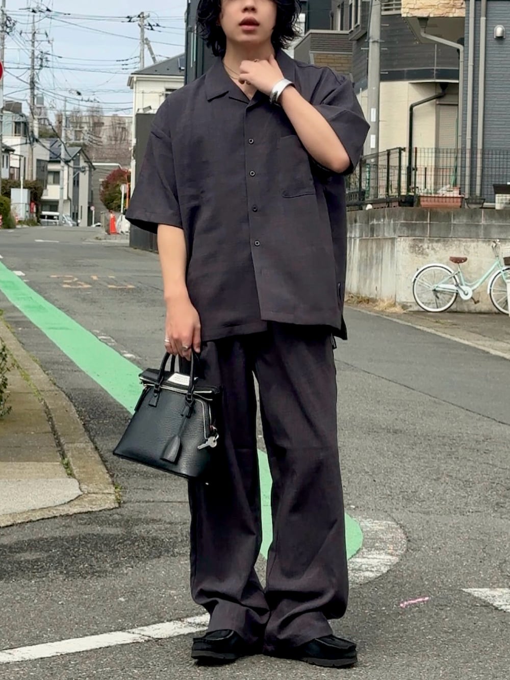 グレー系のシャツ/ブラウス、グレー系のスラックス、ブラック系のスニーカーを着用したメンズの春コーディネートの2枚目の写真