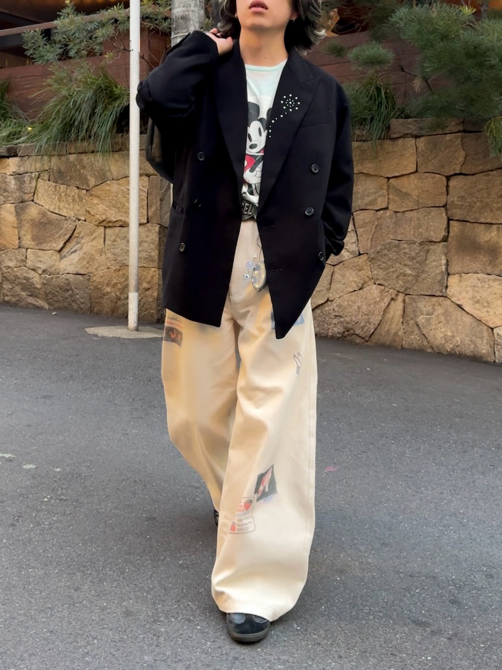 ブラック系のテーラードジャケット、ホワイト系のその他パンツ、ブラック系のスニーカーを着用したメンズの春コーディネートの2枚目の写真