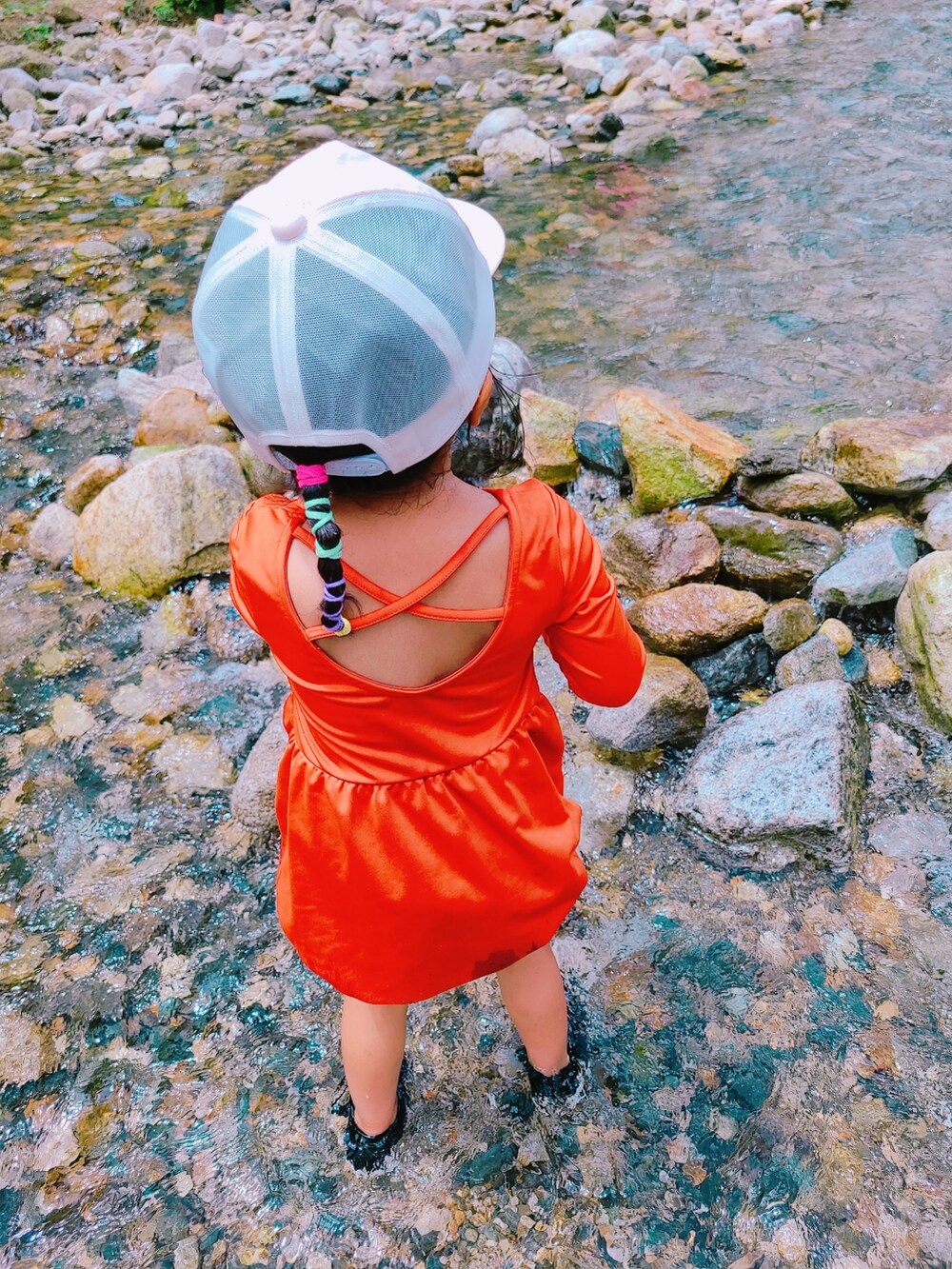 ブラック系のサンダル、ベージュ系のキャップ、オレンジ系の水着を着用したキッズの夏コーディネートの3枚目の写真