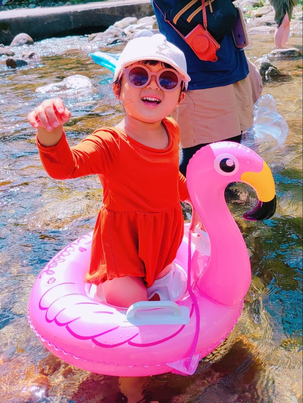 ブラック系のサンダル、ベージュ系のキャップ、オレンジ系の水着を着用したキッズの夏コーディネートの2枚目の写真