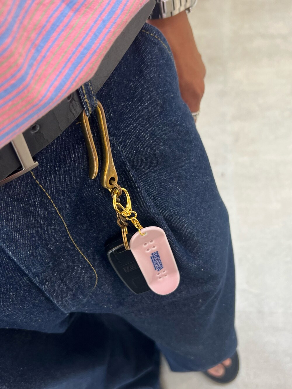 ピンク系のTシャツ/カットソー、ブルー系のデニムパンツ、ブラック系のサンダルを着用したメンズの夏コーディネートの2枚目の写真