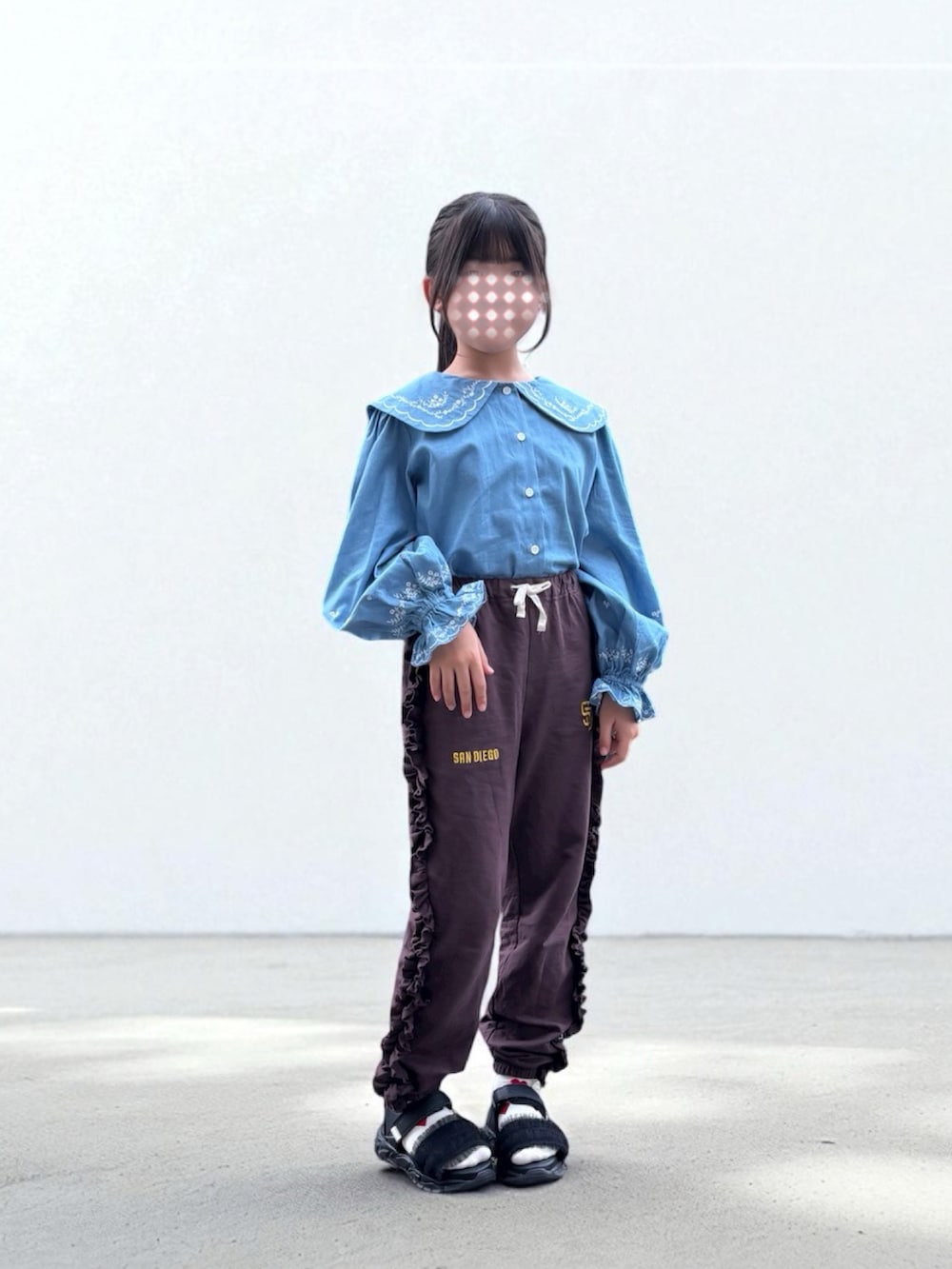 ブルー系のシャツ/ブラウス、ブラウン系のスウェットパンツ、ブラック系のサンダルを着用したレディースの秋コーディネートの2枚目の写真