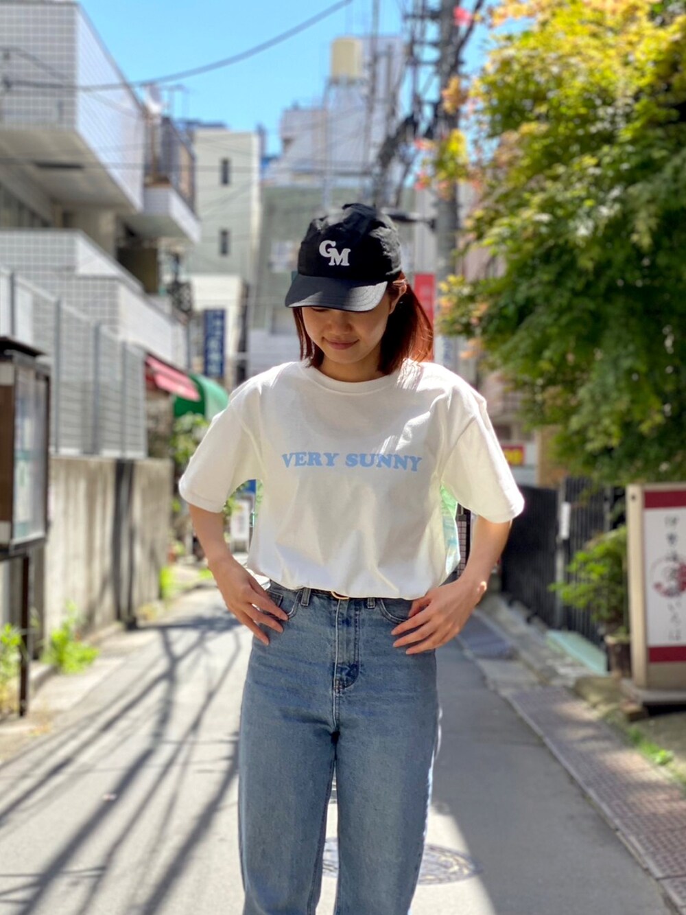 ベージュ系のスニーカー、ホワイト系のTシャツ/カットソー、ブルー系のデニムパンツを着用したレディースの春コーディネートの3枚目の写真