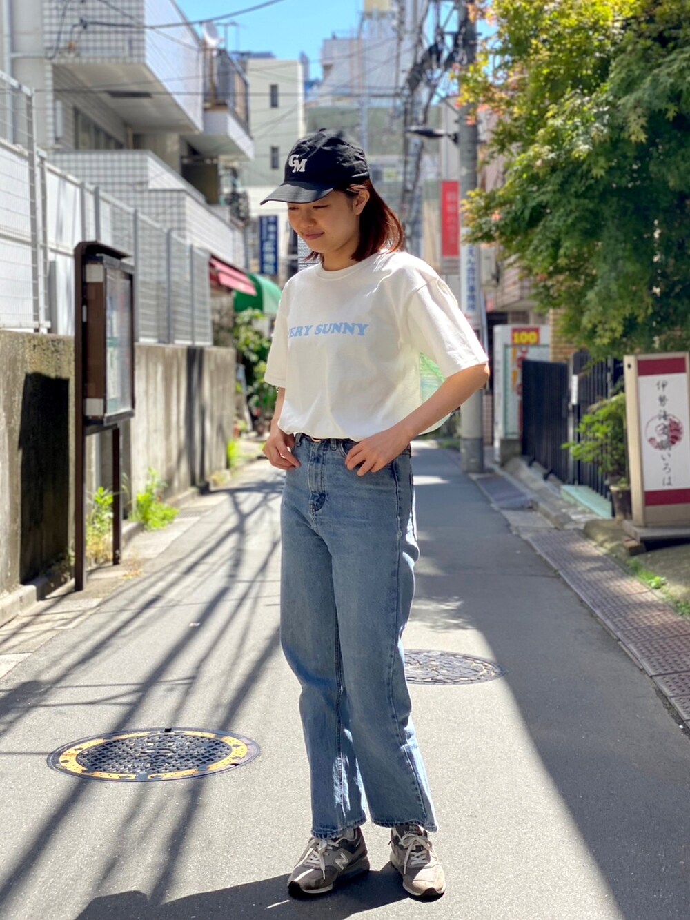 ベージュ系のスニーカー、ホワイト系のTシャツ/カットソー、ブルー系のデニムパンツを着用したレディースの春コーディネートの2枚目の写真