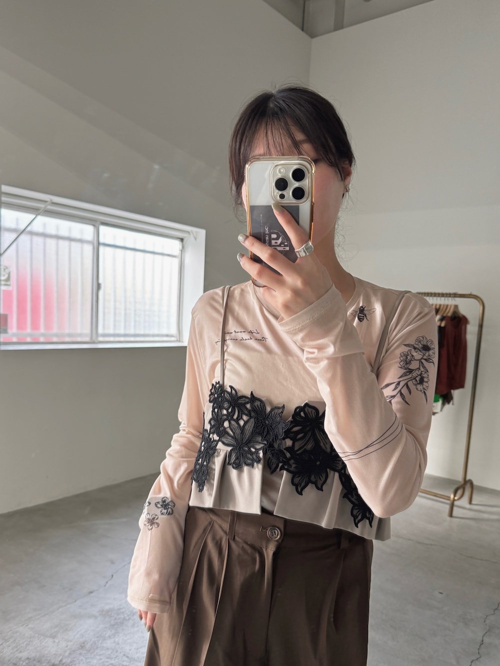 ベージュ系のTシャツ/カットソー、ブラウン系のスラックス、ベージュ系のドレスを着用したレディースの春コーディネートの3枚目の写真