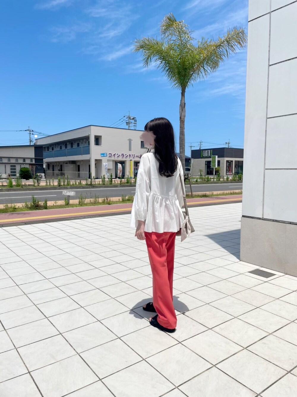 オレンジ系のスラックス、ホワイト系のシャツ/ブラウス、ベージュ系のショルダーバッグを着用したレディースの夏コーディネートの3枚目の写真