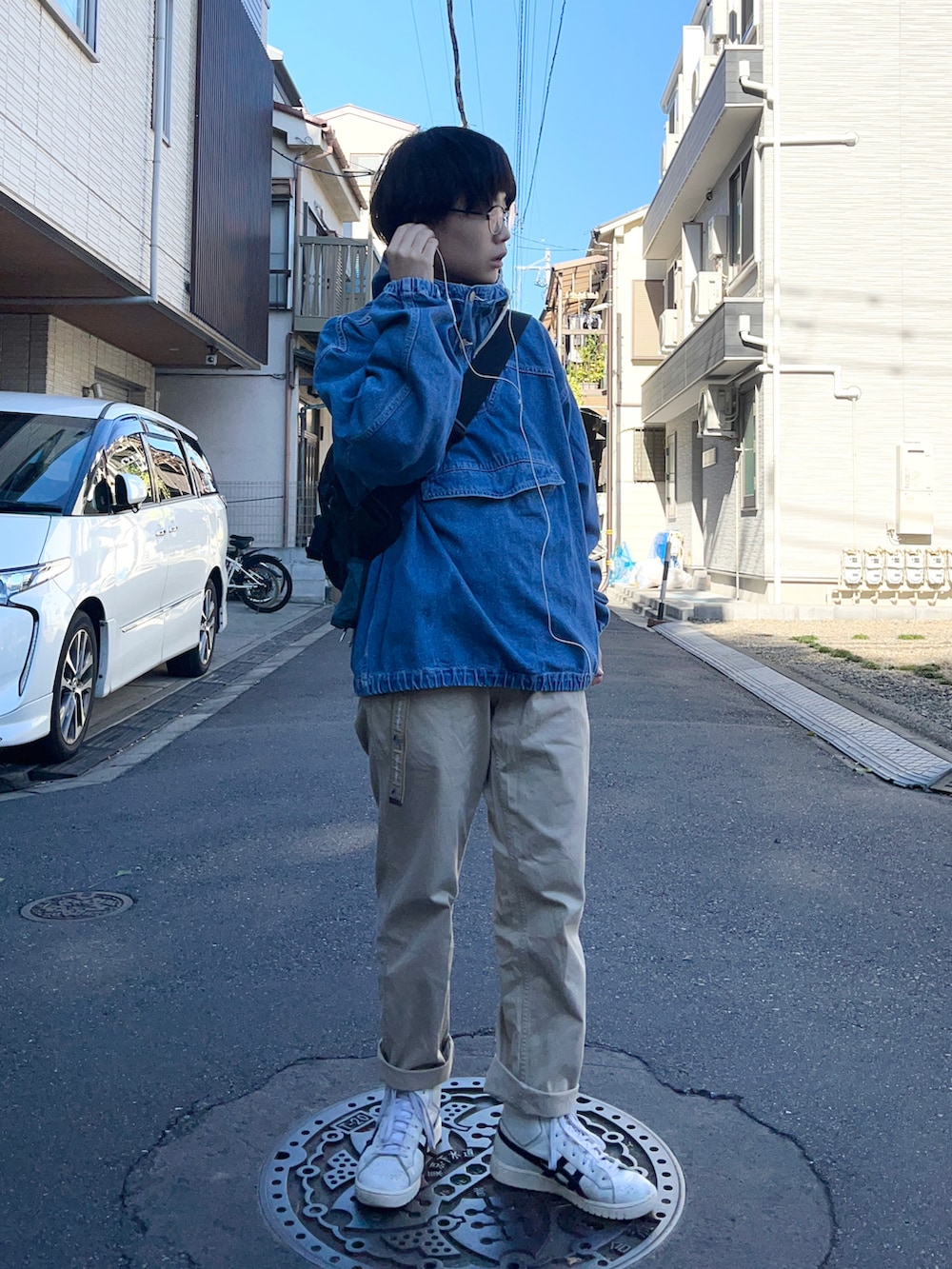 ホワイト系のスニーカー、ブラック系のショルダーバッグ、ブルー系のブルゾンを着用したレディースの秋コーディネートの2枚目の写真