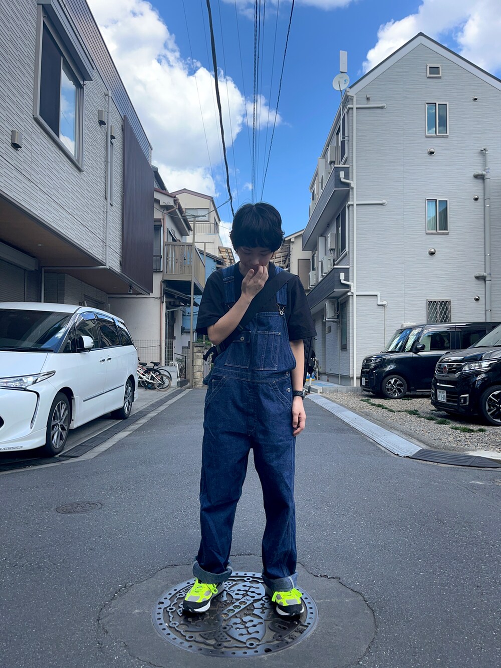 イエロー系のスニーカー、ブルー系のサロペット/オーバーオール、ブラック系のショルダーバッグを着用したレディースの秋コーディネートの2枚目の写真