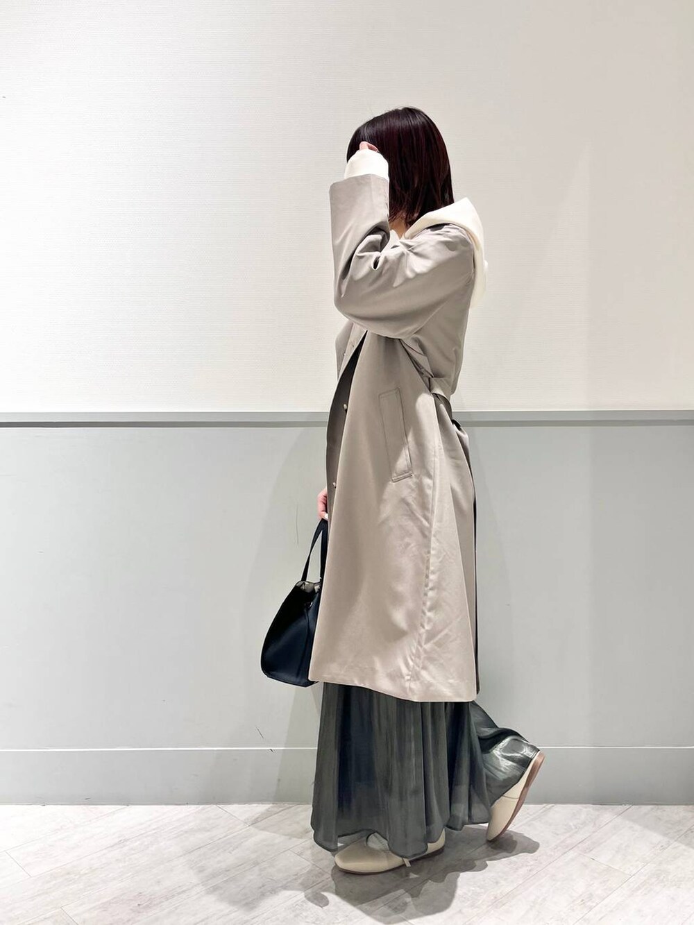 ホワイト系のパンプス、その他のショルダーバッグ、ブラック系のスカートを着用したレディースの冬コーディネートの5枚目の写真