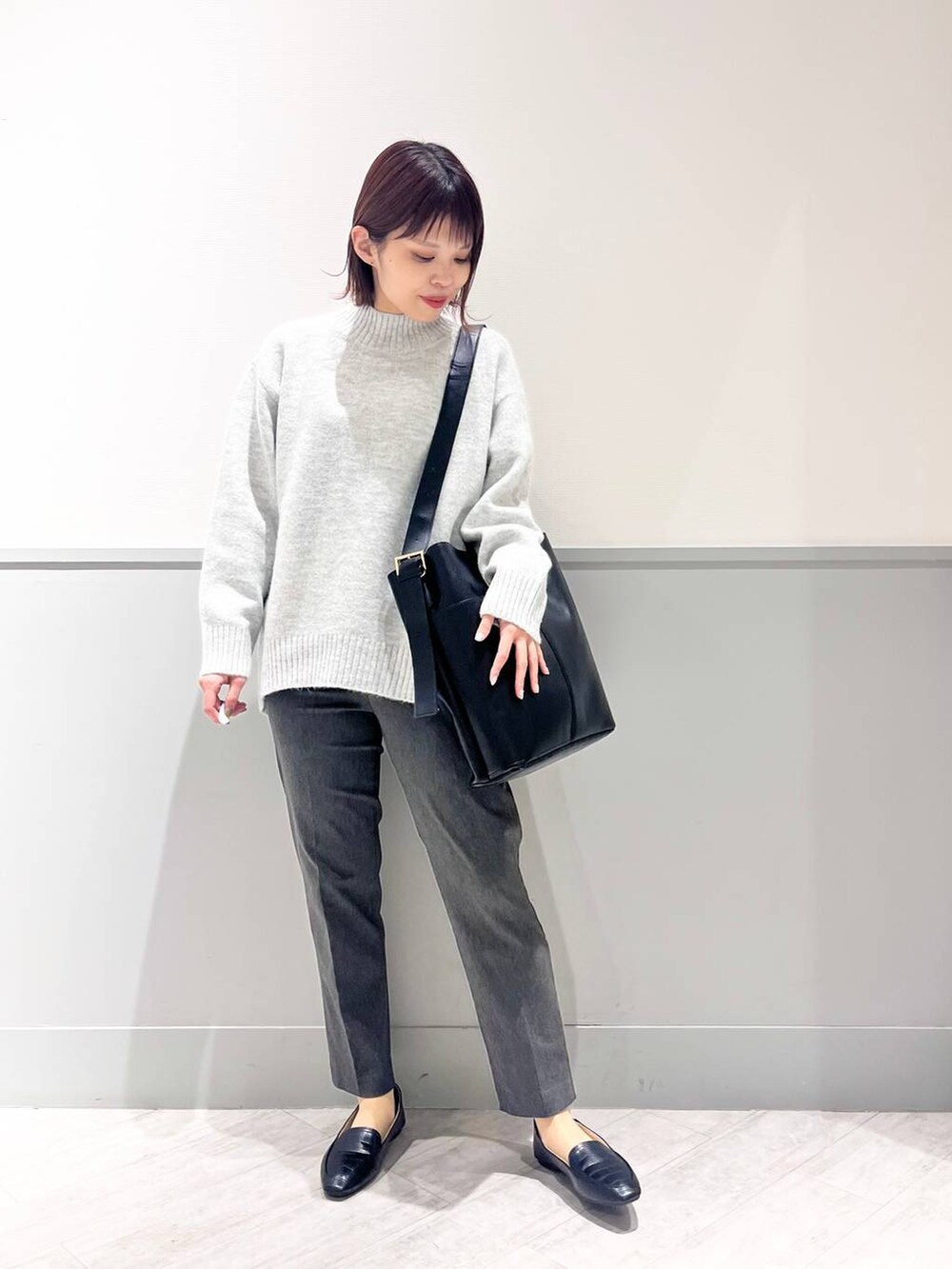 ブラック系のパンプス、グレー系のニット/セーター、ブラック系のショルダーバッグを着用したレディースの冬コーディネートの3枚目の写真