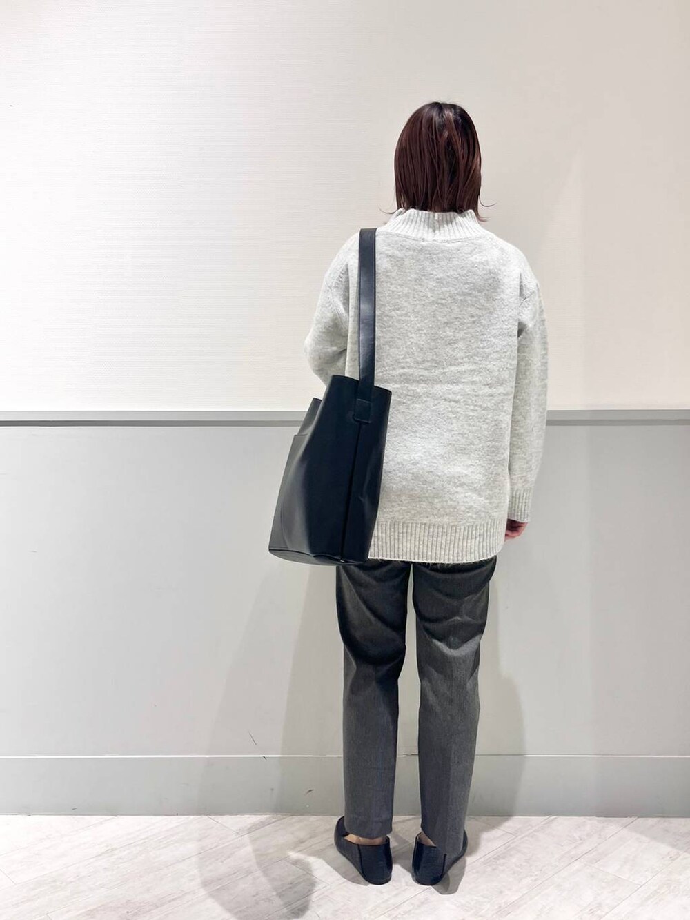 ブラック系のパンプス、グレー系のニット/セーター、ブラック系のショルダーバッグを着用したレディースの冬コーディネートの5枚目の写真