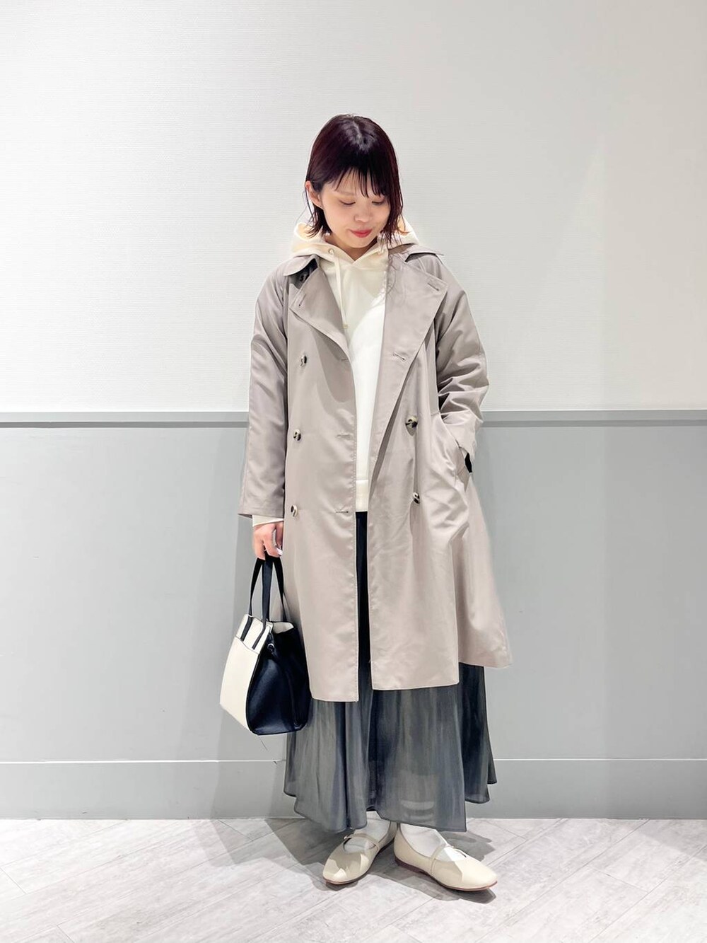 ホワイト系のパンプス、その他のショルダーバッグ、ブラック系のスカートを着用したレディースの冬コーディネートの6枚目の写真