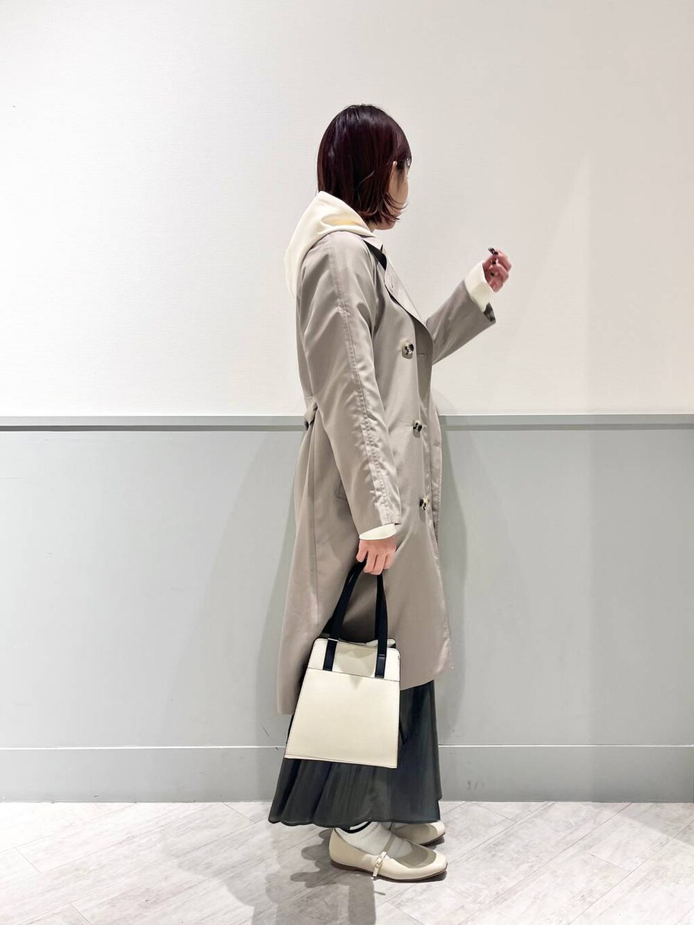 ホワイト系のパンプス、その他のショルダーバッグ、ブラック系のスカートを着用したレディースの冬コーディネートの3枚目の写真