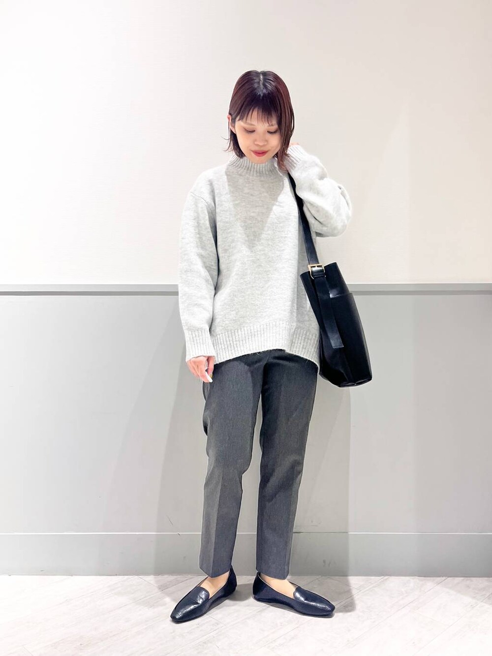 ブラック系のパンプス、グレー系のニット/セーター、ブラック系のショルダーバッグを着用したレディースの冬コーディネートの7枚目の写真
