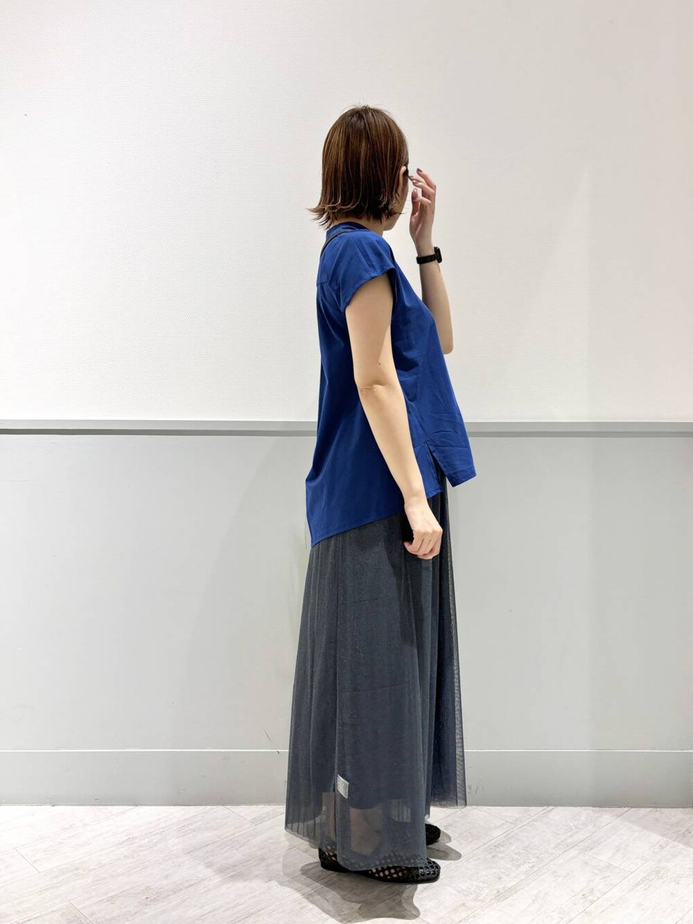 ブラック系のパンプス、ブルー系のTシャツ/カットソー、ブラック系のショルダーバッグを着用したレディースの夏コーディネートの3枚目の写真