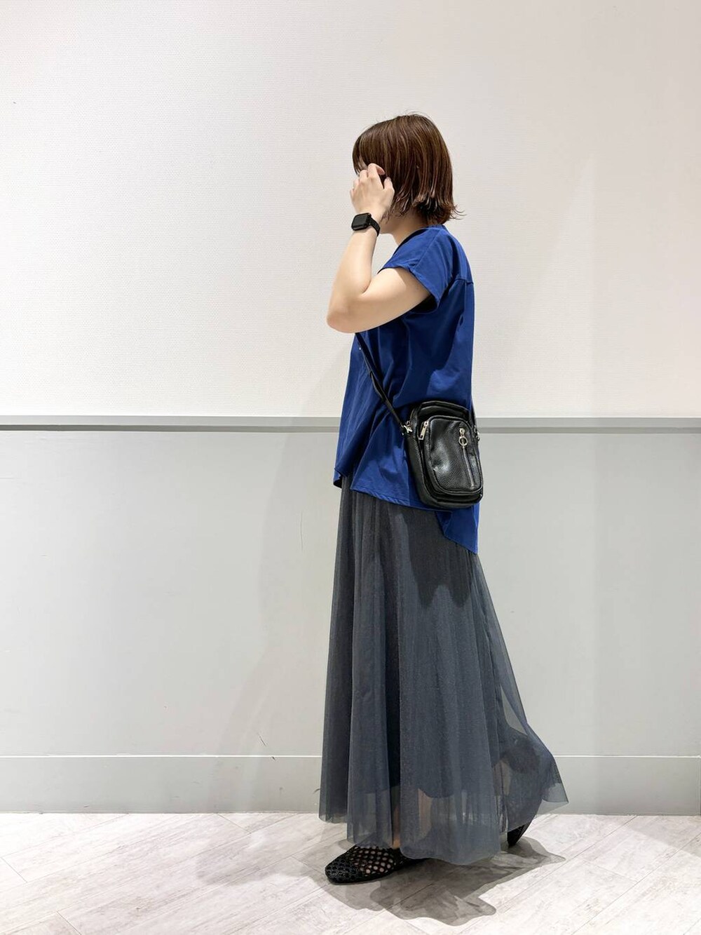 ブラック系のパンプス、ブルー系のTシャツ/カットソー、ブラック系のショルダーバッグを着用したレディースの夏コーディネートの5枚目の写真