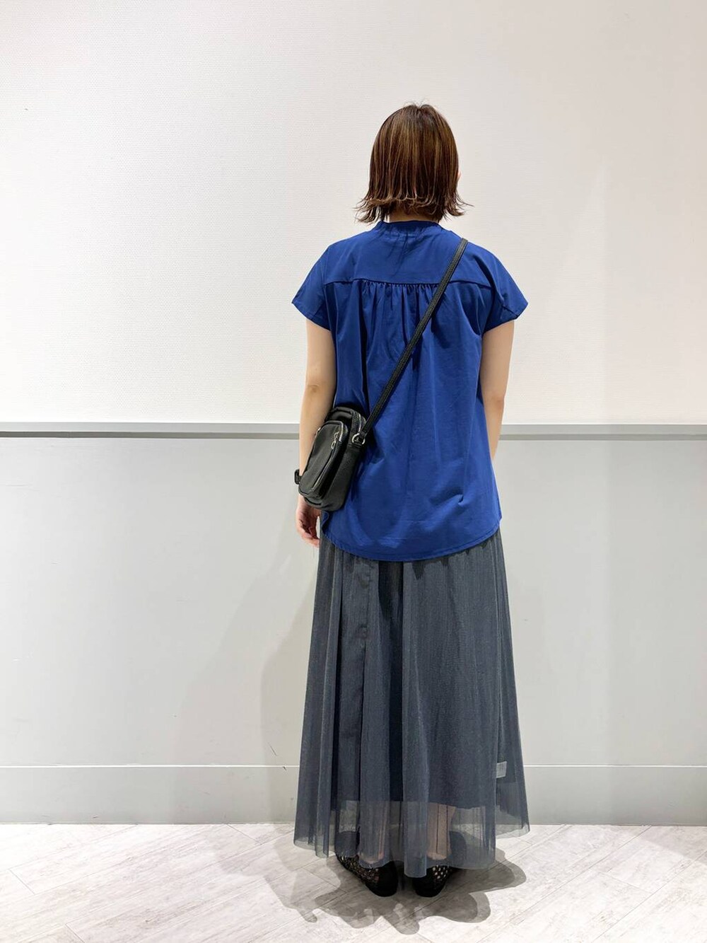 ブラック系のパンプス、ブルー系のTシャツ/カットソー、ブラック系のショルダーバッグを着用したレディースの夏コーディネートの4枚目の写真