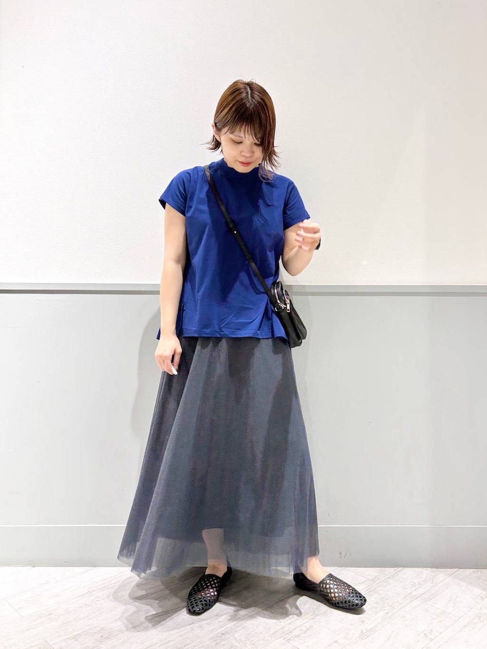 ブラック系のパンプス、ブルー系のTシャツ/カットソー、ブラック系のショルダーバッグを着用したレディースの夏コーディネートの2枚目の写真