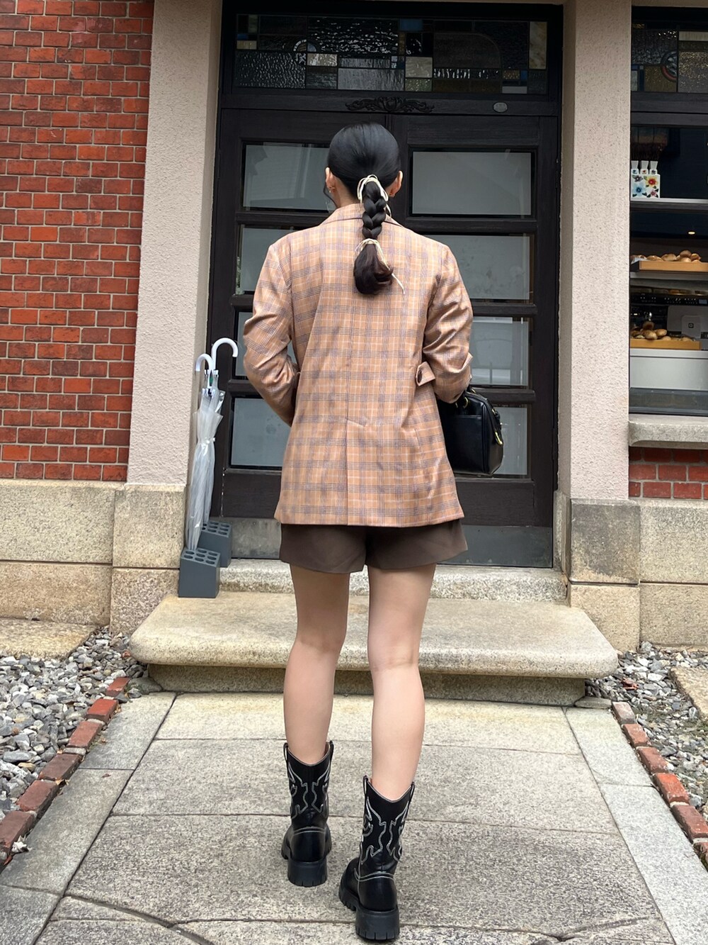 ホワイト系のTシャツ/カットソー、ブラウン系のテーラードジャケット、ブラック系のバッグを着用したレディースの秋コーディネートの2枚目の写真