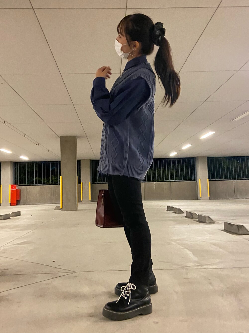 ブルー系のシャツ/ブラウス、レッド系のハンドバッグ、ブラック系のデニムパンツを着用したレディースの秋コーディネートの2枚目の写真