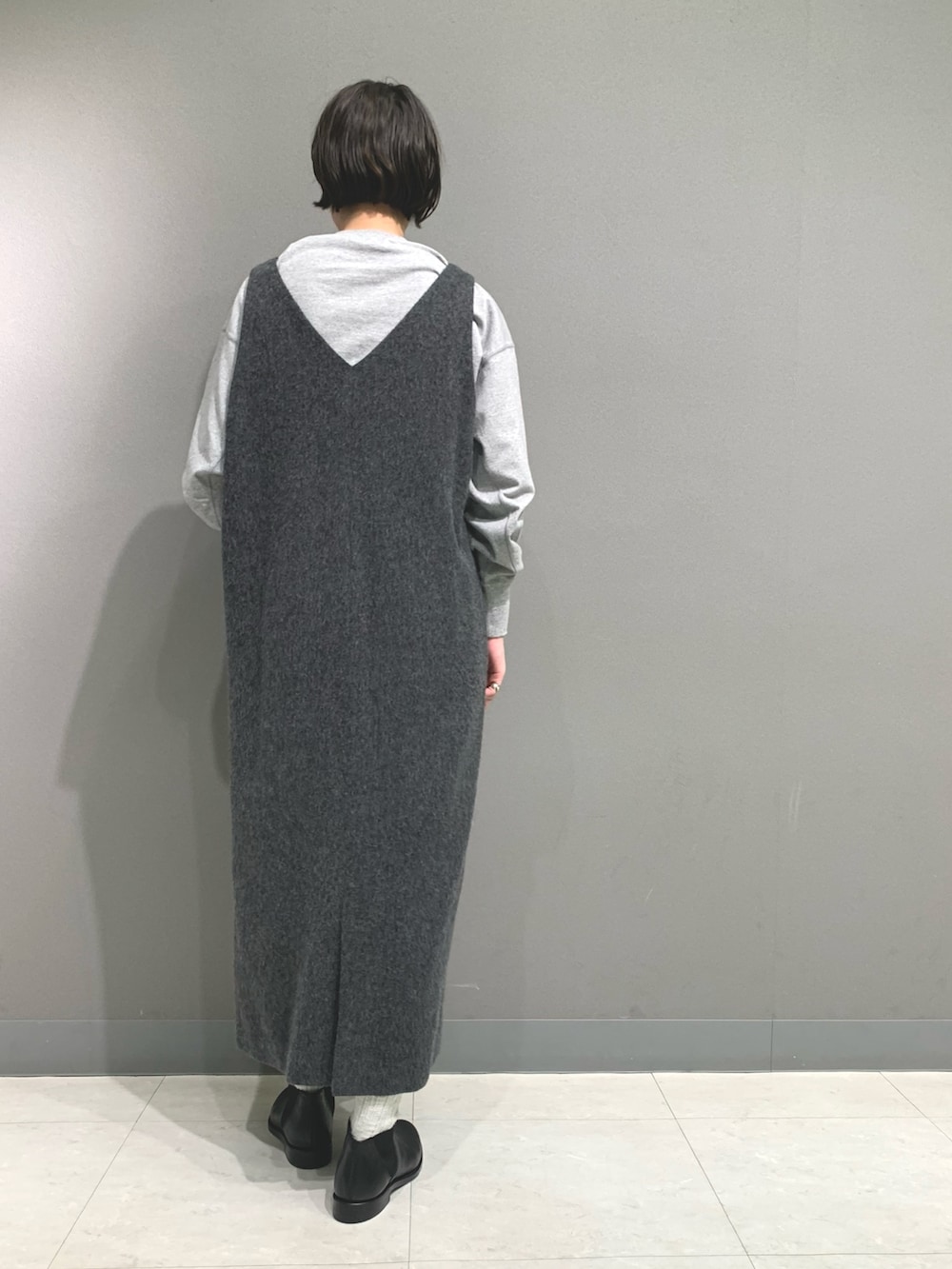 グレー系のTシャツ/カットソー、グレー系のワンピース、ブラック系のブーツを着用したレディースの秋コーディネートの4枚目の写真