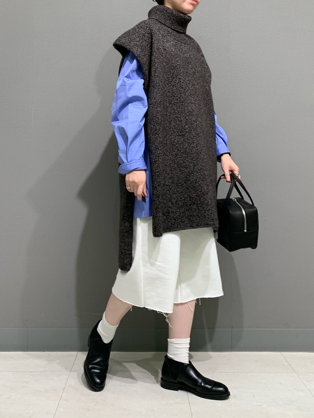 ブラウン系のニット/セーター、ブルー系のシャツ/ブラウス、ホワイト系のその他パンツを着用したレディースの秋コーディネートの4枚目の写真