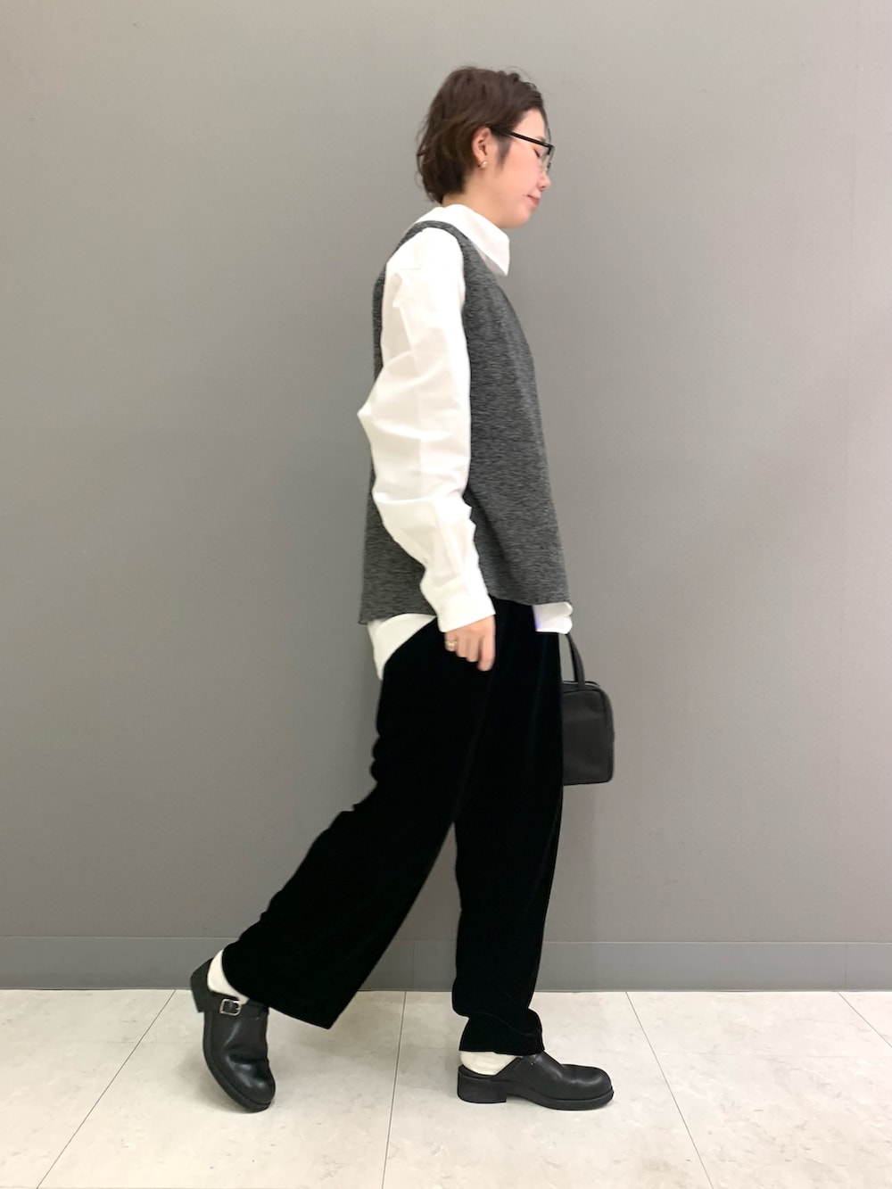 グリーン系のニット/セーター、ホワイト系のシャツ/ブラウス、ブラック系のその他パンツを着用したレディースの秋コーディネートの2枚目の写真