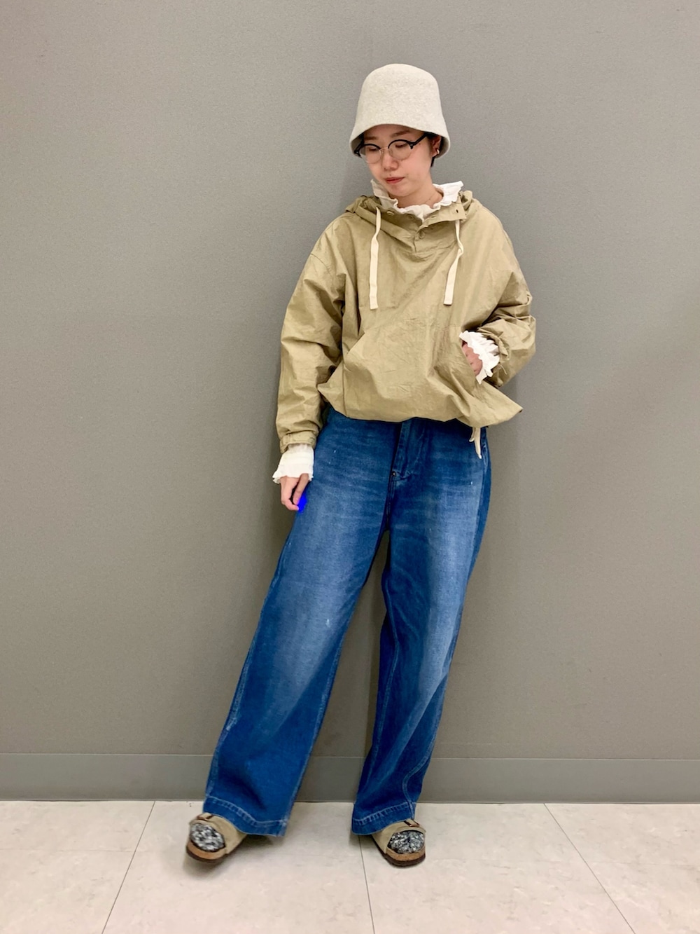 ブルー系のデニムパンツ、ベージュ系のTシャツ/カットソー、ホワイト系のシャツ/ブラウスを着用したレディースの秋コーディネートの5枚目の写真