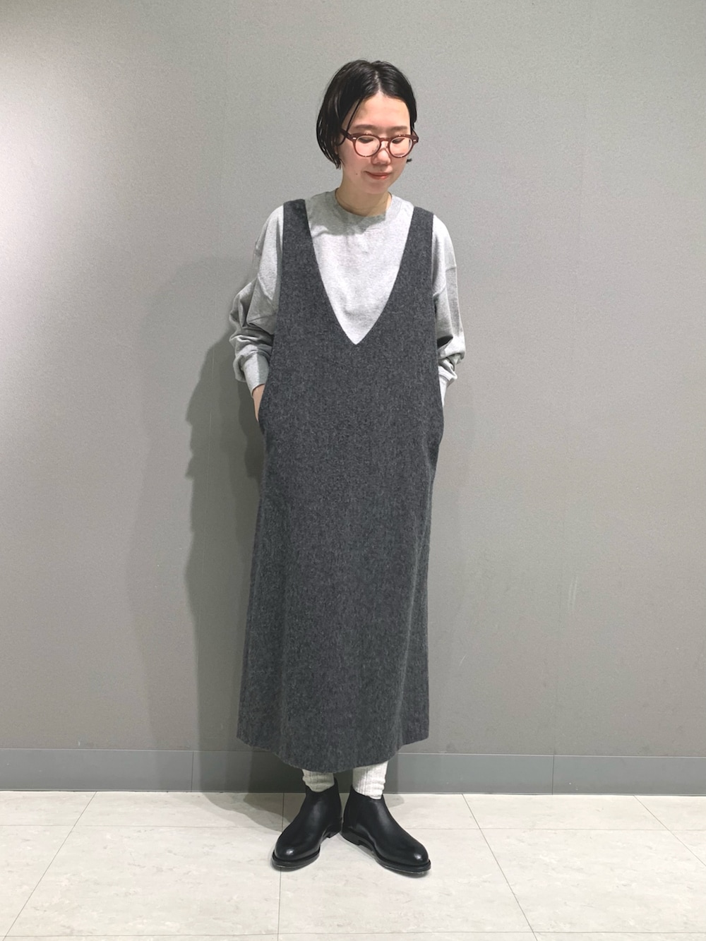 グレー系のTシャツ/カットソー、グレー系のワンピース、ブラック系のブーツを着用したレディースの秋コーディネートの2枚目の写真