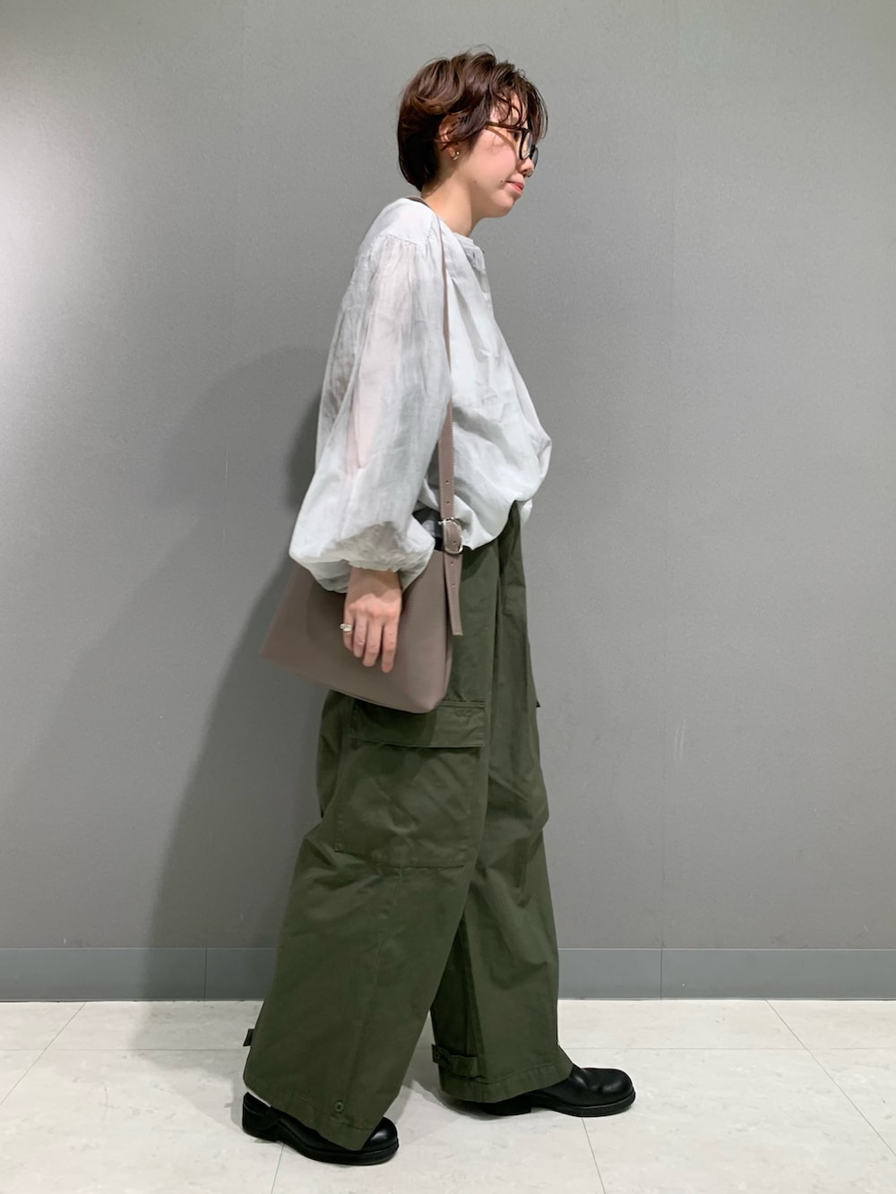 グレー系のシャツ/ブラウス、ホワイト系のタンクトップ、グリーン系のその他パンツを着用したレディースの秋コーディネートの3枚目の写真