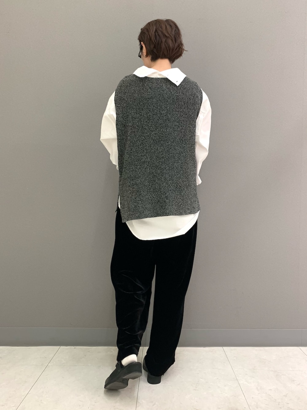 グリーン系のニット/セーター、ホワイト系のシャツ/ブラウス、ブラック系のその他パンツを着用したレディースの秋コーディネートの3枚目の写真