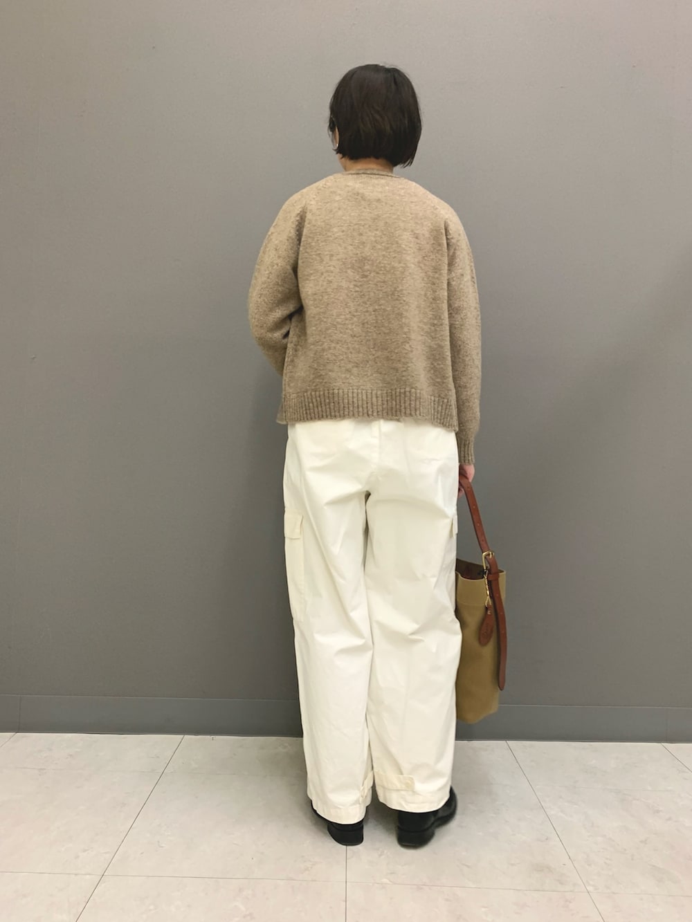 ホワイト系のその他パンツ、ブルー系のショルダーバッグ、ブラック系のブーツを着用したレディースの秋コーディネートの3枚目の写真