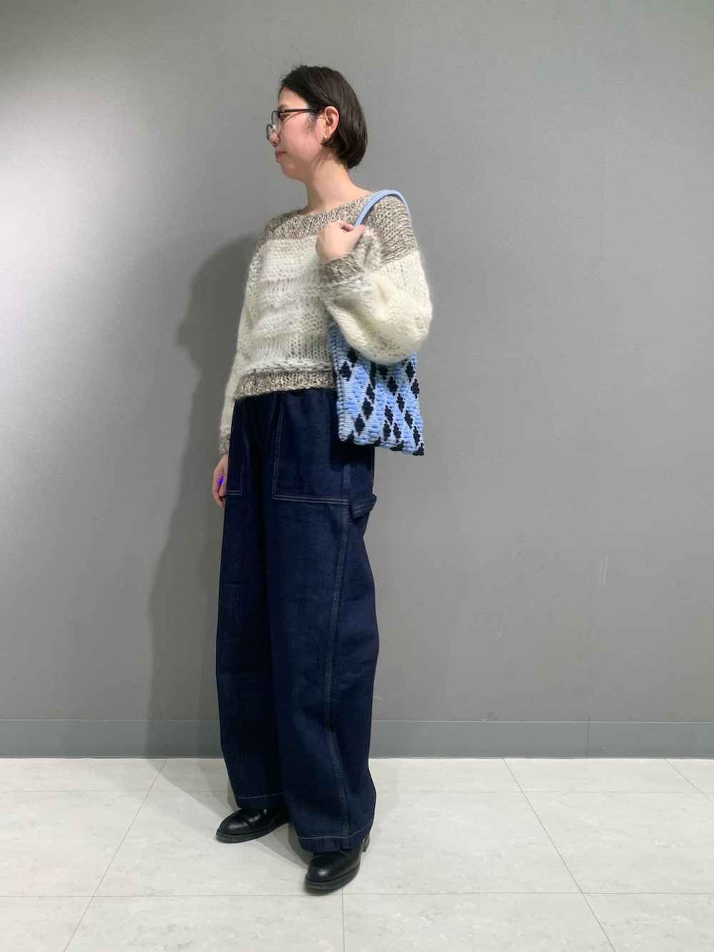 ブルー系のその他パンツ、ホワイト系のニット/セーター、ブラック系のブーツを着用したレディースの冬コーディネートの6枚目の写真