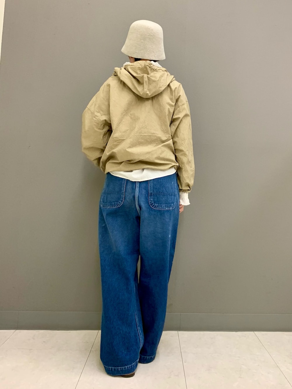 ブルー系のデニムパンツ、ベージュ系のTシャツ/カットソー、ホワイト系のシャツ/ブラウスを着用したレディースの秋コーディネートの6枚目の写真