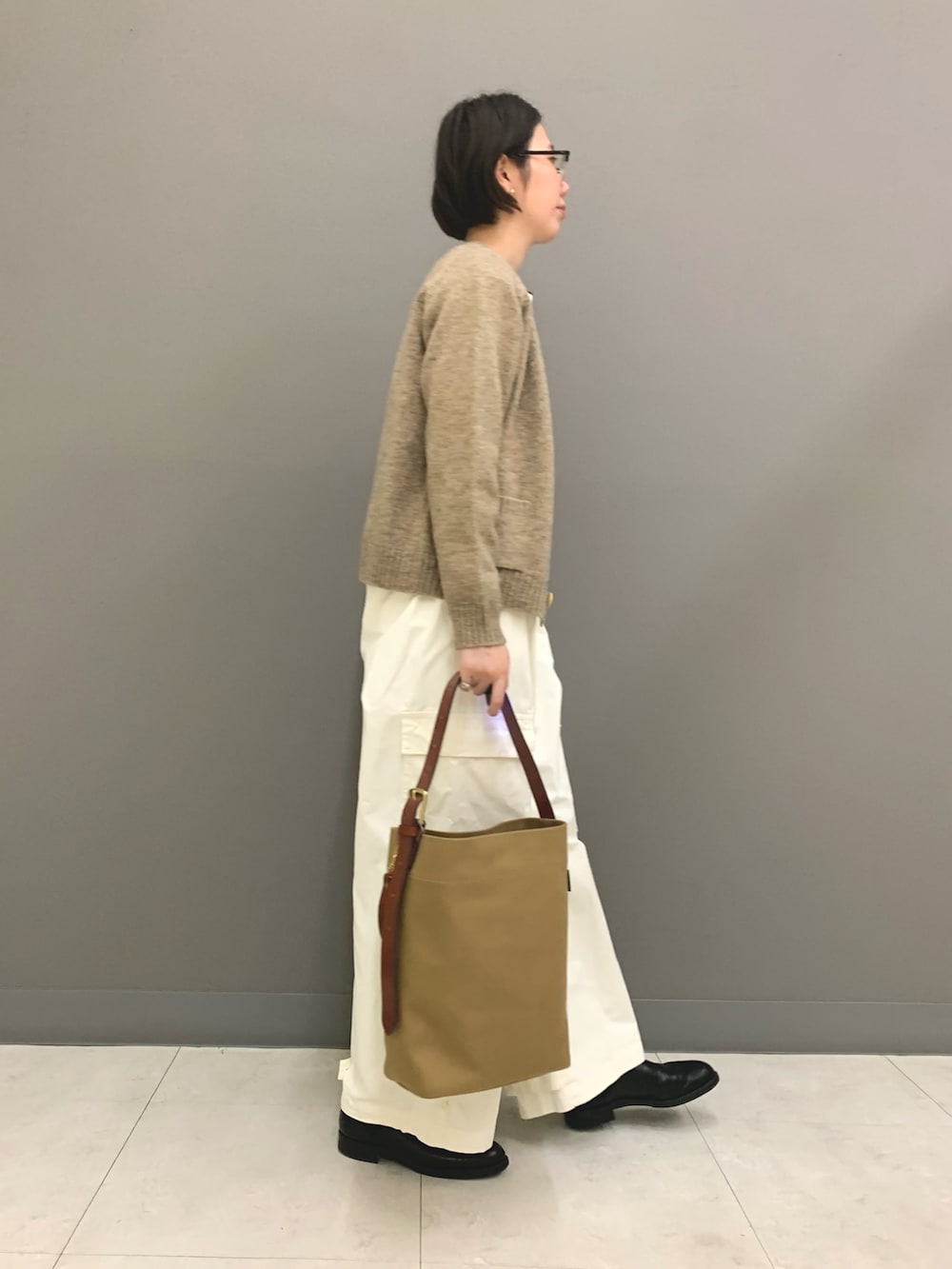 ホワイト系のその他パンツ、ブルー系のショルダーバッグ、ブラック系のブーツを着用したレディースの秋コーディネートの2枚目の写真